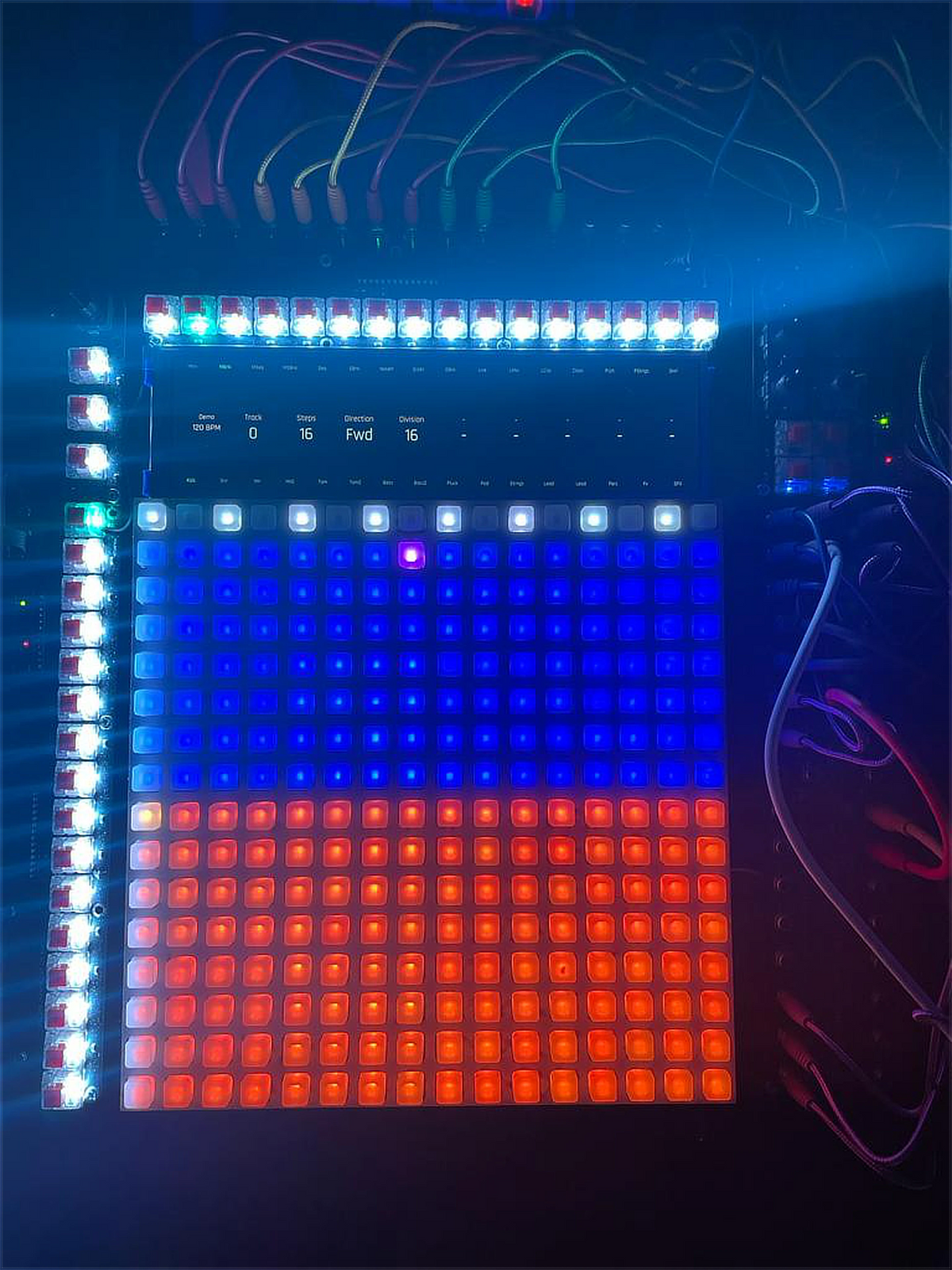 Early Reliq prototype with a lit pad grid, a small screen and patch cables above it