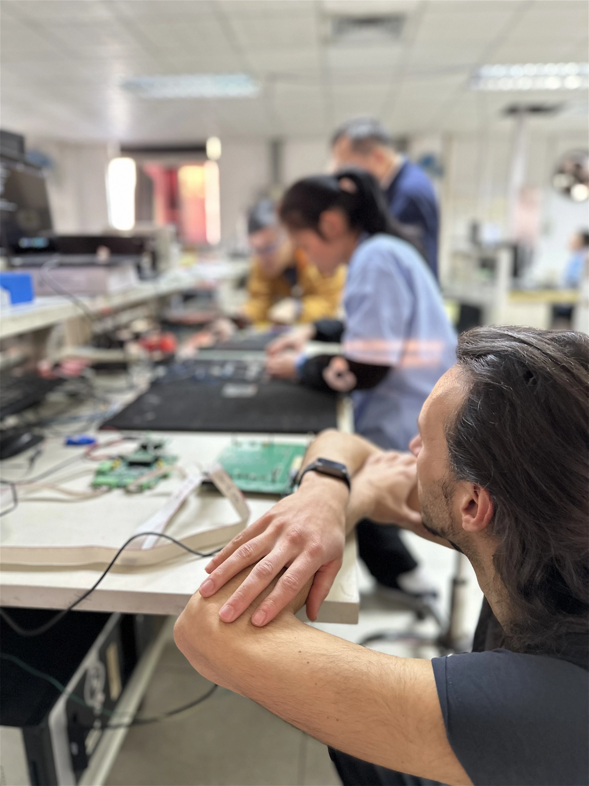 At a production partner's workbench in China, with display boards on the table