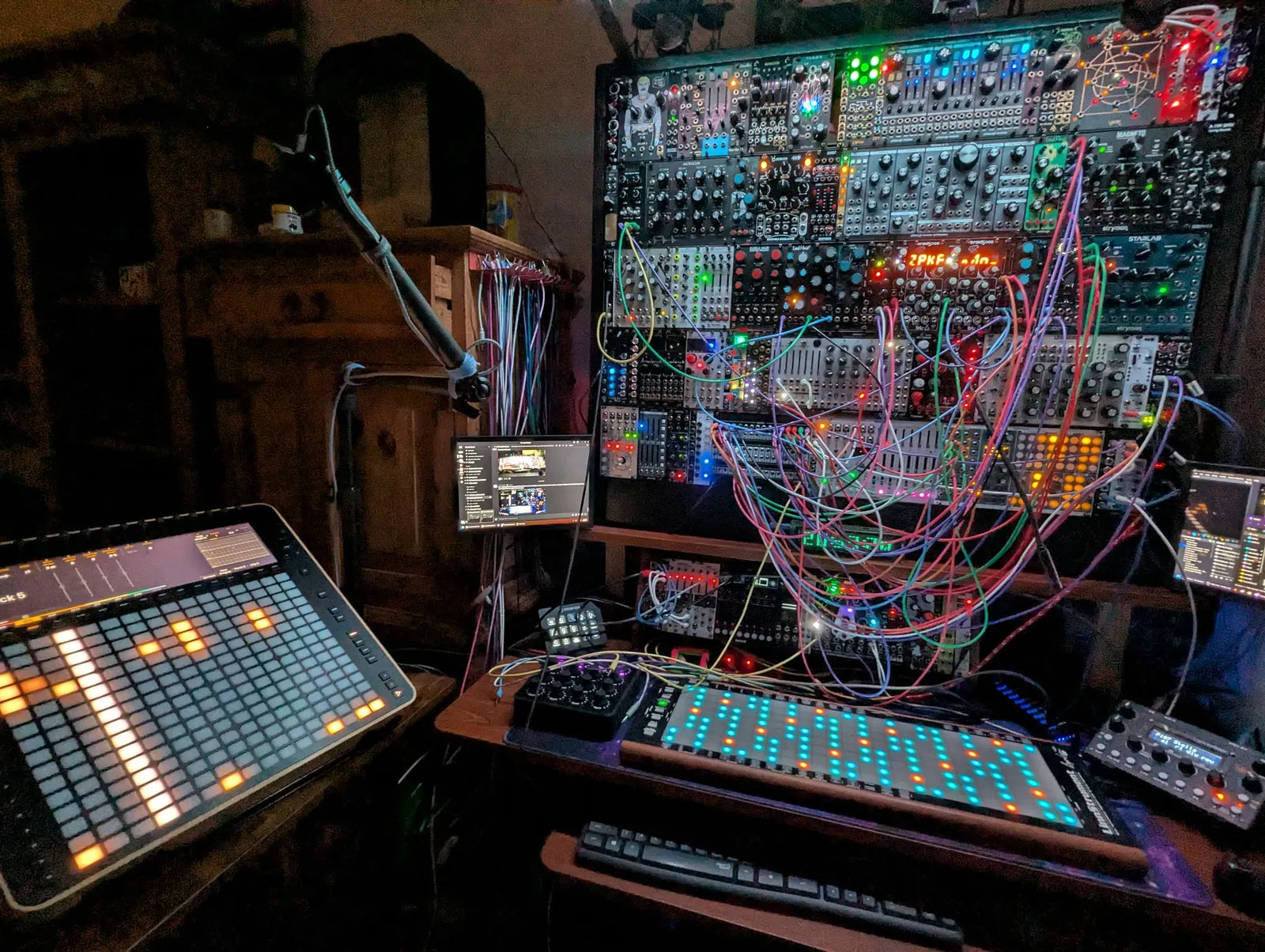 A patched modular system with Reliq lit in orange on the desk below it